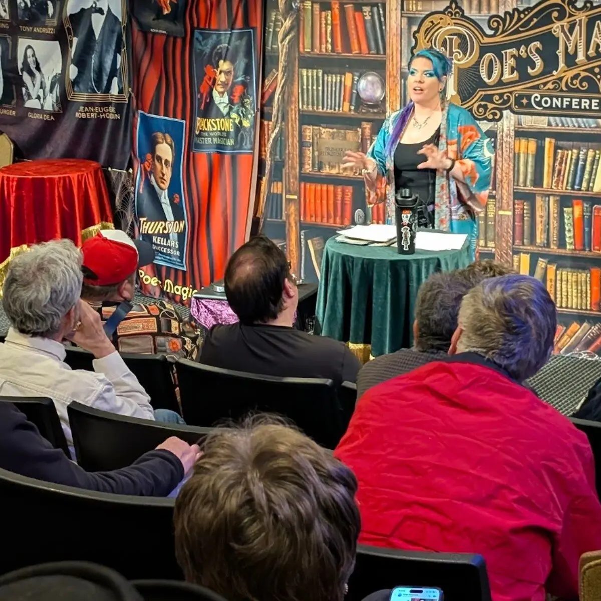 A featured artist lecturing about storytelling magic before conference guests