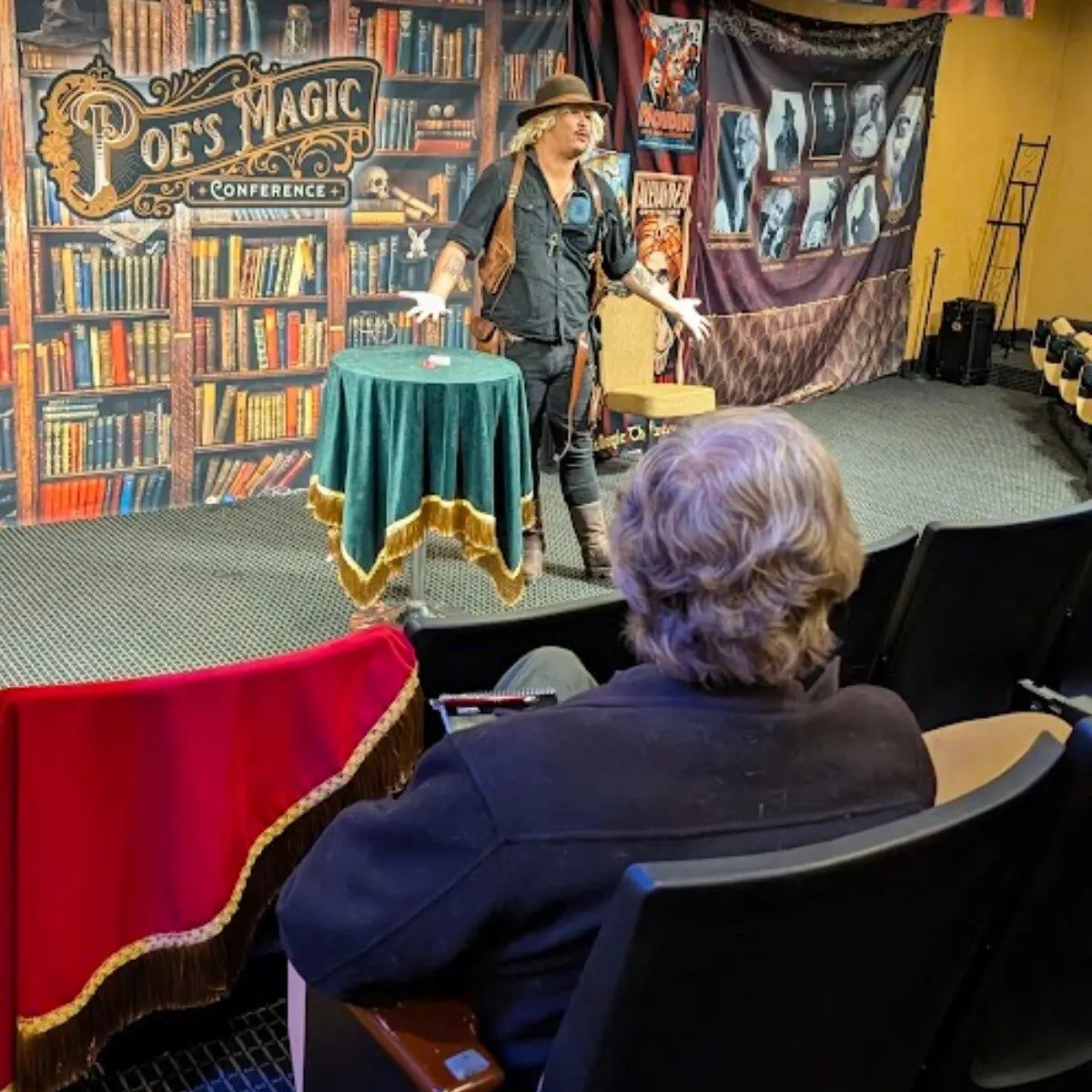 A magician performing at a draped table during the Baltimore magic conference