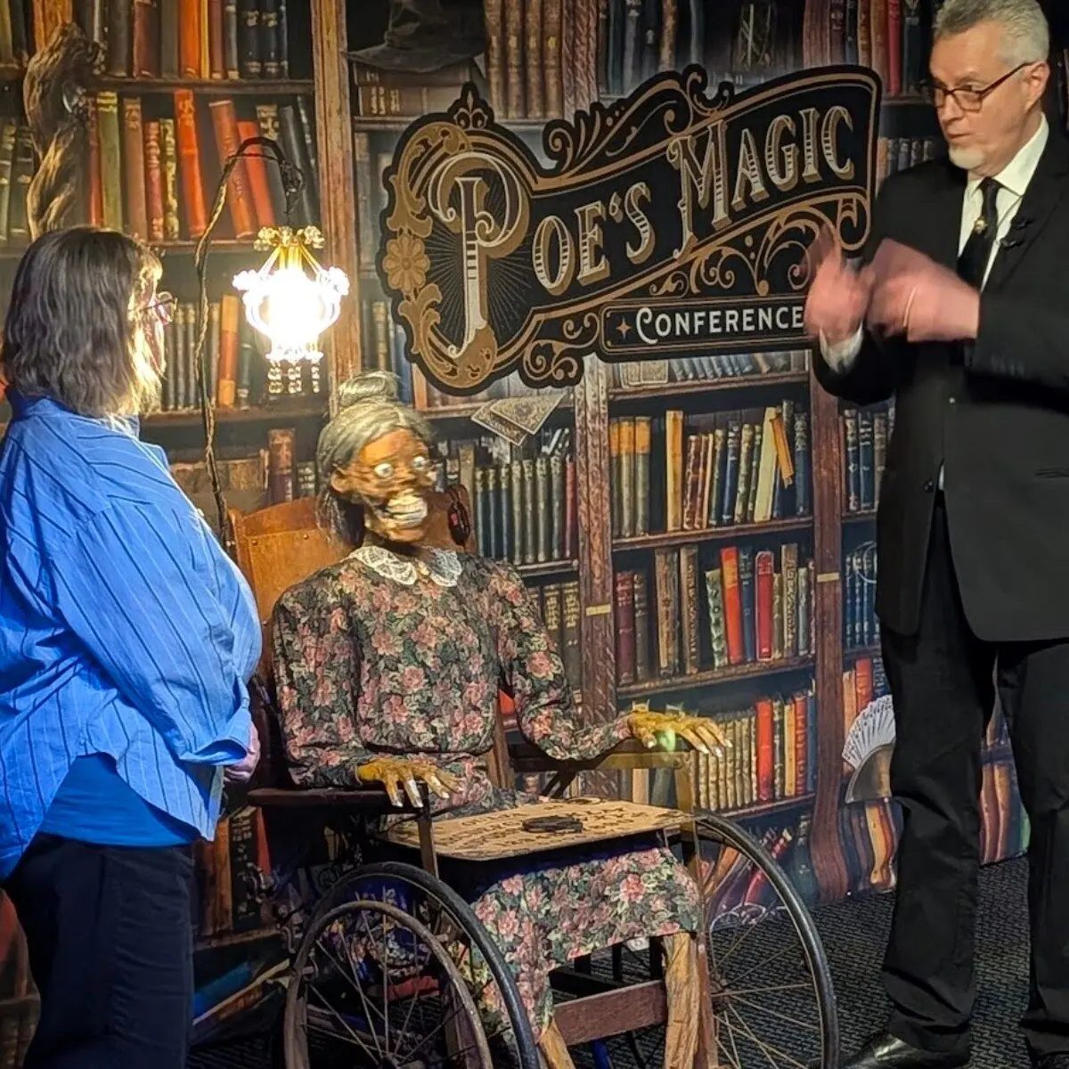 A mystery performance with a seated participant at Poe's Magic Conference