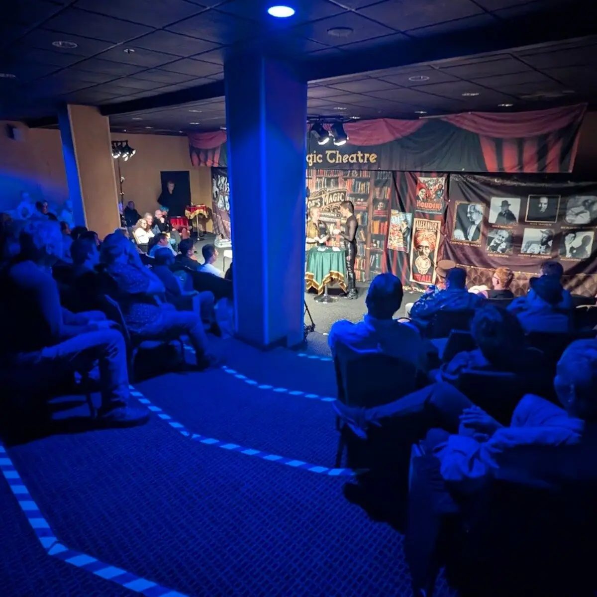 Conference guests watching a performance inside Poe's Magic Theatre
