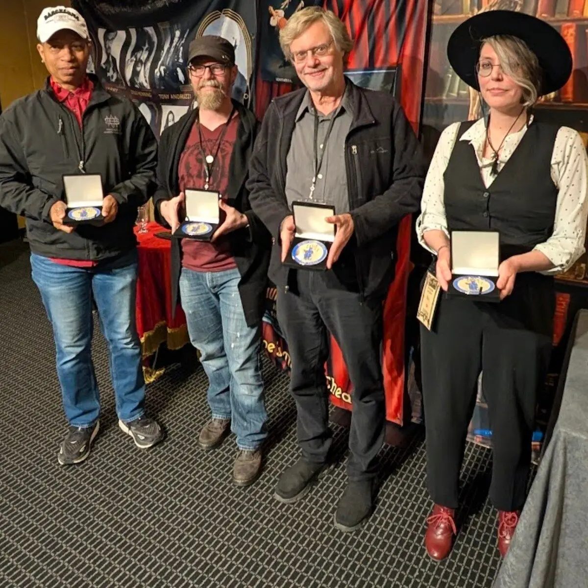 Four recipients displaying awards at Poe's Magic Conference in Baltimore